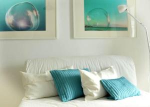巴耶格兰雷伊Molino Azul 3A, Wohnung mit Meerblick的白色的沙发,上面有蓝色和白色的枕头