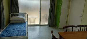 首尔汉斯旅馆的一间医院间,配有一张床和一张桌子及椅子