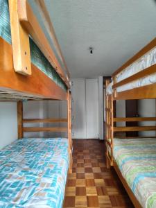 基多Mi Casa的铺有木地板的客房内配有两张双层床。