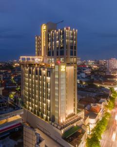 泗水Platinum Hotel Tunjungan Surabaya的一座大建筑,晚上有钟