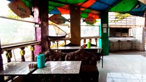 马林迪Baba Lao Hotel的一间设有桌椅的餐厅,位于带窗户的房间内