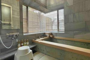 Ajiro雅 南熱海 温泉別荘 Ocean View Hotspring Villa的带浴缸的浴室和窗户。