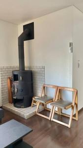 Ajiro雅 南熱海 温泉別荘 Ocean View Hotspring Villa的客厅配有两把椅子和炉灶