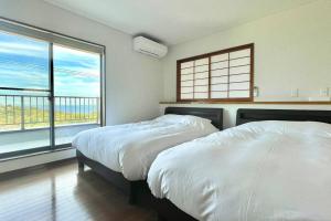 Ajiro雅 南熱海 温泉別荘 Ocean View Hotspring Villa的带2扇窗户的客房内的2张床