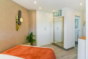 马拉加Apartamento a un paso del mar的卧室配有一张床,墙上设有镜子
