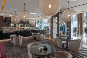 阿布扎比阿布扎比罗塔纳公园酒店的餐厅设有桌椅和吊灯。