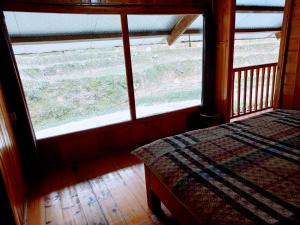 萨帕Madame View Homestay的卧室在窗户前配有一张床