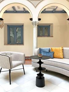 塞维利亚Itaca Sevilla by Soho Boutique的客厅配有沙发和桌椅