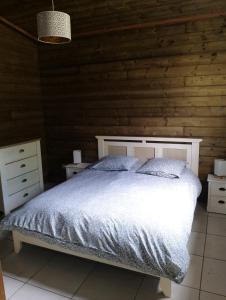 萨拉济L'escale du Tec-Tec的卧室设有白色的床和木墙