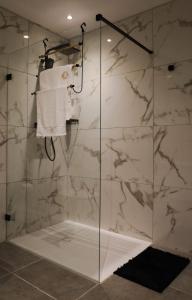 圣保罗湾城Large Seafront Maisonette的浴室设有玻璃淋浴间和白色大理石墙壁。