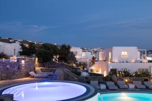 米克诺斯城波尔图米科诺斯酒店的享有游泳池的夜间景色,拥有白色建筑