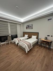 泰基尔达Akel Guest House的一间卧室设有两张床、一张桌子和一个壁炉