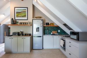 诺丁汉路Dornoch on Gowrie Farm, Nottingham Road的厨房配有白色橱柜和冰箱。