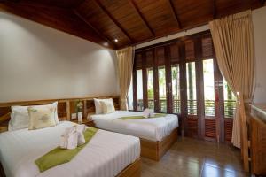 Ban Khok LoMadee Spa & Resort的带窗户的客房内的两张床