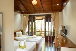 Ban Khok LoMadee Spa & Resort的酒店客房设有两张床和电视。
