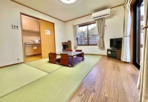 Sekishoato雅 芦ノ湖 別荘 箱根 Miyabi Ashinoko villa hakone的大型客厅配有桌子和电视
