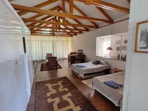 哈拉雷Weaver Cottages的一间卧室配有两张床、一张桌子和一把椅子