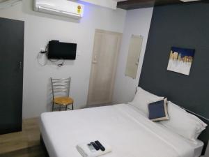 钦奈Silver Cloud Hotel Sholinganallur的卧室配有白色的床和电视。