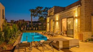 博德鲁姆Bodrum Ortakent Luxury Private Villa with Pool的后院设有游泳池、椅子和房屋