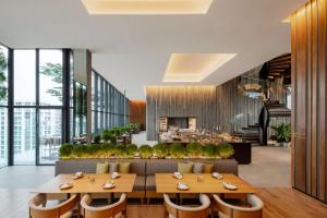 哥打京那巴鲁Hyatt Centric Kota Kinabalu的一间带桌椅的餐厅和一个大堂