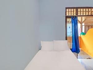 CupelSPOT ON 92404 Pondok Ai的窗户客房内的一张白色床