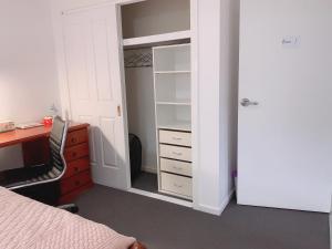 黄金海岸Home Away From Home-(Room1)的一间卧室配有一张床、一张书桌和一个衣柜