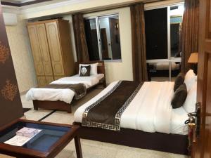 穆扎法拉巴德Muzaffarabad View Motel的酒店客房设有两张床和一张桌子。