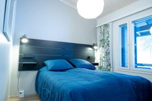 普哈圣山Pyhä Snowflake的一间卧室配有一张蓝色的床和一个大床头板