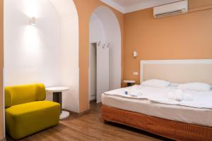 布达佩斯地铁酒店的一间卧室配有一张床和一张黄色椅子