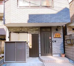 东京D27-Outstanding convenience 4DK/ Shinjuku Okubo的一间房子的前门,有一扇棕色的门