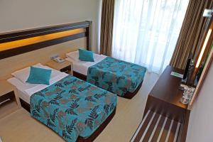 阿拉尼亚希芒酒店的酒店客房设有两张床和一张桌子。