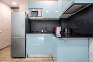 雷乌斯Apartments Lilia Reus的厨房配有蓝色橱柜和不锈钢冰箱