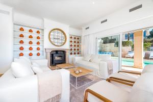 Sol de MallorcaLuxury Villa with panoramic sea views的客厅配有白色家具和壁炉
