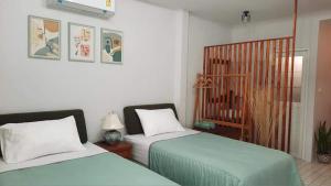 甲米镇Bann Kam B&B的一间卧室配有两张床和一张婴儿床。