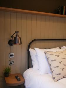 EatonWaggon and Horses, Eaton, Congleton的一间卧室配有一张带台灯和桌子的床