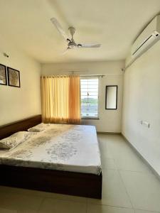 那格浦尔2BHK luxurious beautiful flat near IIM AIIMS的一间卧室配有一张带吊扇和窗户的床。