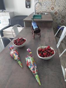 埃尔托尔诺Apartamentos La Chaparrina del Jerte的一张桌子上放着两碗樱桃和一辆玩具车