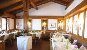 Iffeldorf兰德加斯托奥斯特希酒店的用餐室配有桌椅和白色的桌布