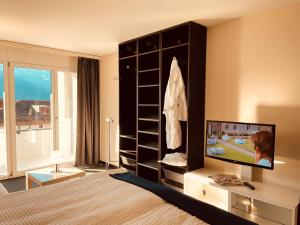 盖尔绍Seehotel Riviera at Lake Lucerne的一间卧室配有一张床,并在一间客房内配有电视。