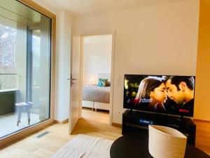 卢森堡Luxury Brand New Flat with Terrace & Parking - RTL1的带平面电视的客厅和卧室