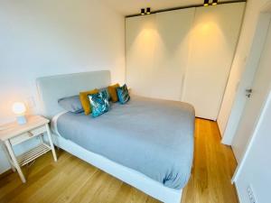 卢森堡Luxury Brand New Flat with Terrace & Parking - RTL1的一间小卧室,配有蓝色的床和边桌