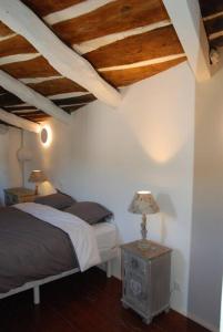 Fressacgrand gîte de charme en Cévennes的一间卧室配有一张床和一张带台灯的桌子
