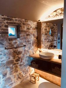 门德里西奥Locanda San Silvestro - Meride的一间带石墙和水槽的浴室
