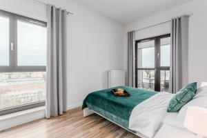 华沙City View Apartments的白色卧室设有床和大窗户
