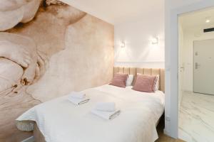 科沃布热格Aquabaltic Apartments Aquarius II的一间卧室配有带白色床单和粉红色枕头的床。