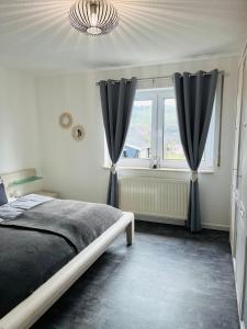 PlaueFerienwohnung am Tor zum Thüringer Wald 2的一间卧室配有床和带窗帘的窗户