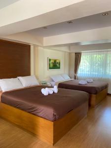Ban Muang Ton Mamuang三M山区度假酒店的卧室内的两张床和毛巾