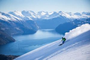 斯特兰达Holiday home among the pearls of Norway的一个人在雪覆盖的山里滑雪