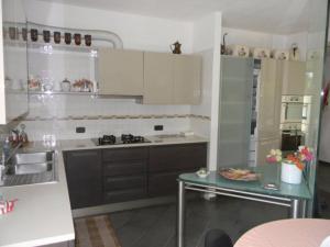 洛阿诺casa vacanza Carly的厨房配有白色橱柜和桌子