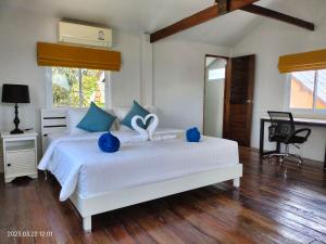 班泰Sand Terrace Beach Bungalows的卧室配有一张蓝色色调的大型白色床。